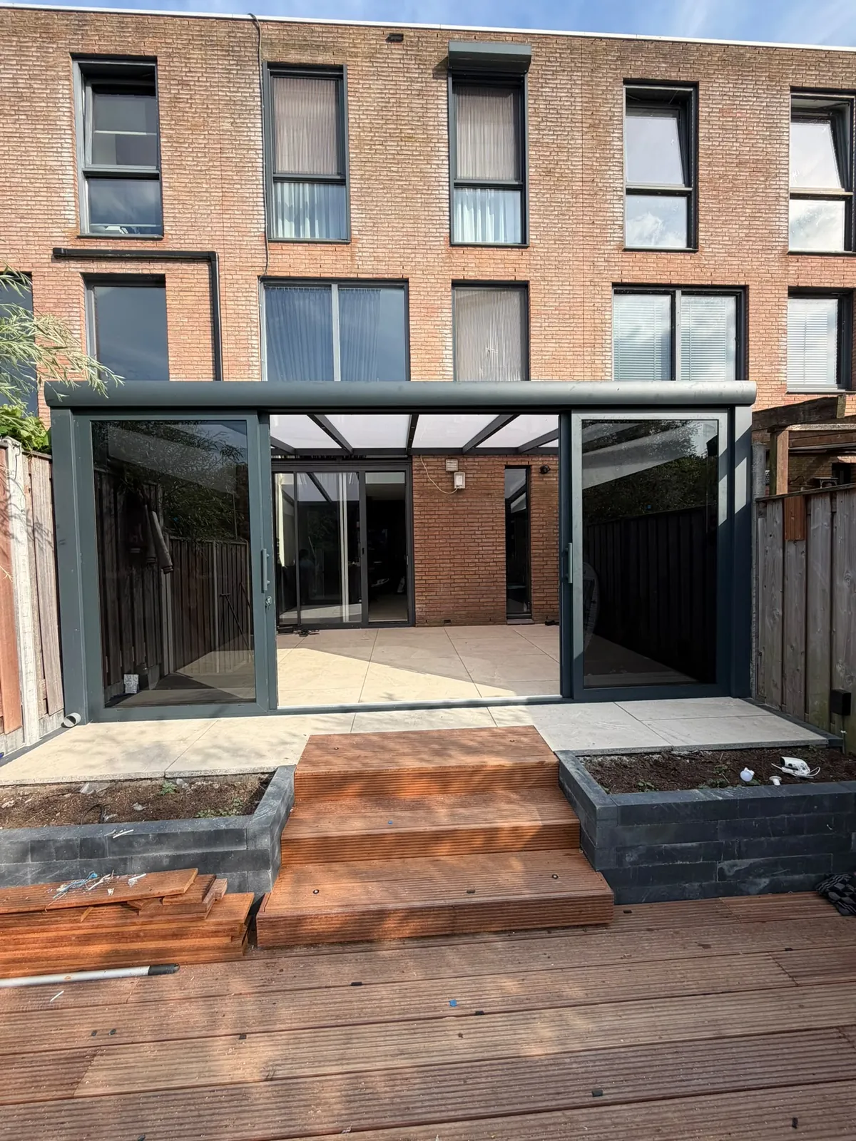 Veranda met geopende glazen schuifwanden en een houten terras