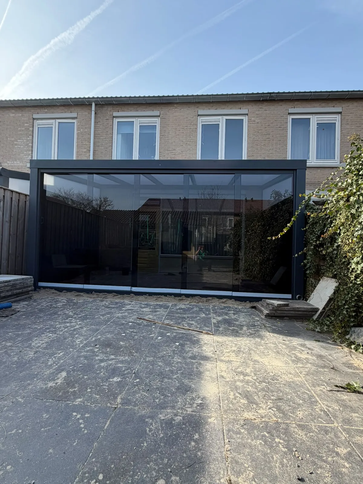 Glazen veranda aan een bakstenen gevel