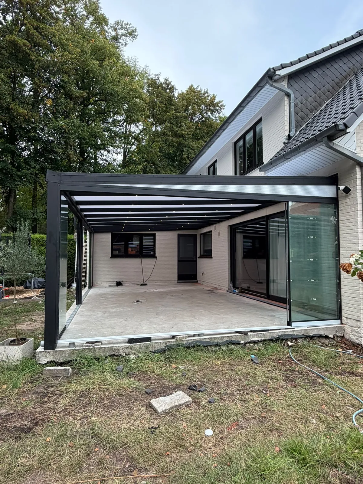 Open terrasoverkapping aan een witte gevel
